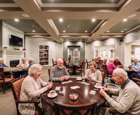 Elderly Residents Playing Cards Together Around a Table at an Assisted Living Facility Elderly Residents Playing Cards Together Around a Table at an Assisted Living Facility