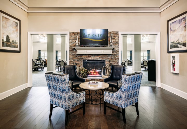 Elegant Lobby Sitting Area With Stone Fireplace and Patterned Chairs at an Assisted Living Facility Elegant Lobby Sitting Area With Stone Fireplace and Patterned Chairs at an Assisted Living Facility