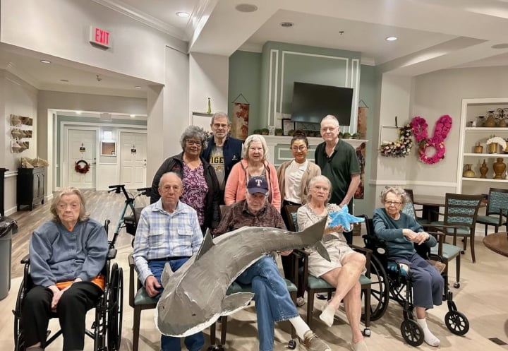 Elderly Residents and Staff Gathered Together for a Group Activity at a Memory Care Community Elderly Residents and Staff Gathered Together for a Group Activity at a Memory Care Community