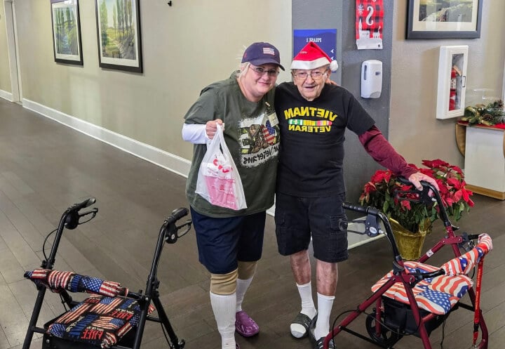 Two Elderly Veterans Posing Together in a Decorated Holiday Hallway at an Assisted Care Community Two Elderly Veterans Posing Together in a Decorated Holiday Hallway at an Assisted Care Community