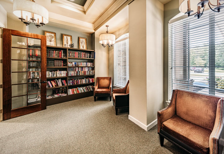 Cozy Resident Library With Bookshelves and Comfortable Seating at a Memory Care Community Cozy Resident Library With Bookshelves and Comfortable Seating at a Memory Care Community
