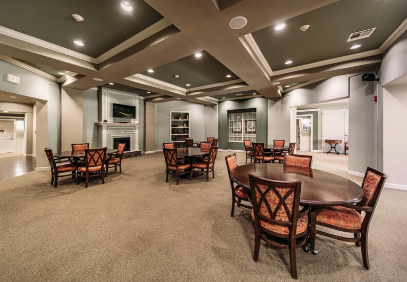 Spacious Elegant Dining Room With Round Tables and Fireplace at an Independent Living Facility Spacious Elegant Dining Room With Round Tables and Fireplace at an Independent Living Facility