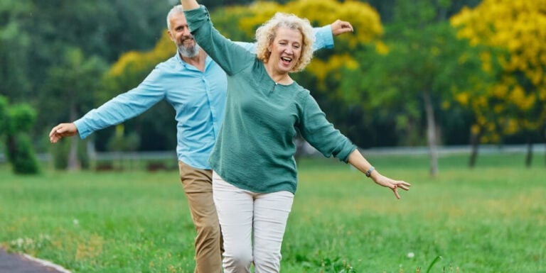 Elderly Couple Running Joyfully Outdoors at Independent Living Facility